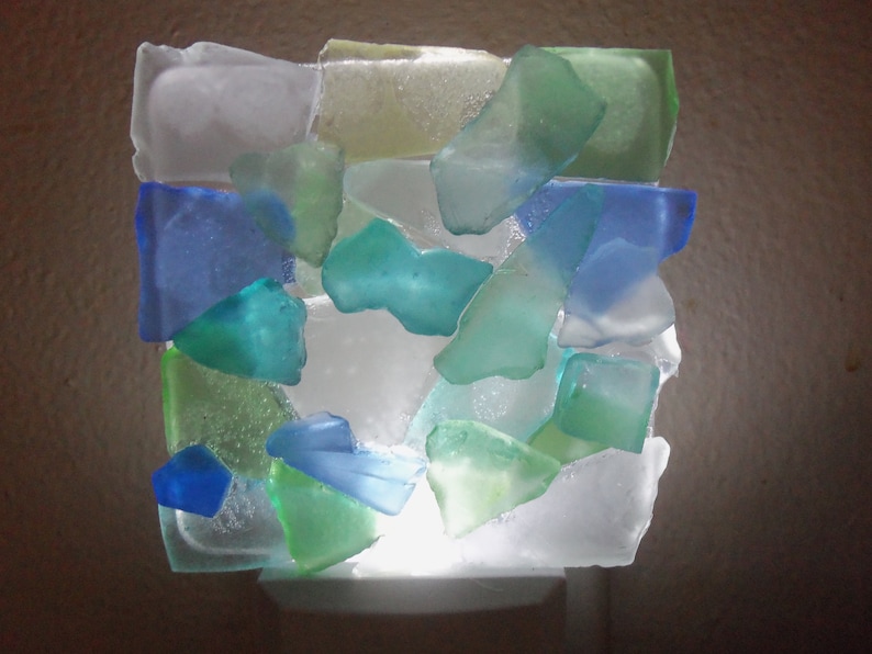 K&ouml;nnte beinhalten: Ein Nachtlicht aus Meerglas in Blaut&ouml;nen, Gr&uuml;n und Wei&szlig;. Die Glassplitter sind in einem Mosaikmuster angeordnet.