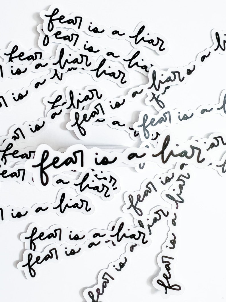 May include: A collection of black and white stickers with the text "fear is a liar" repeated multiple times. The stickers are scattered on a white background.