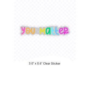 Op de afbeelding: Een transparante sticker met de tekst "you matter" in regenboogkleuren. De sticker is 3,0 inch bij 0,6 inch.
