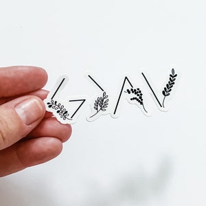 May include: A white sticker with the word "Grateful" written in black with a simple floral design.