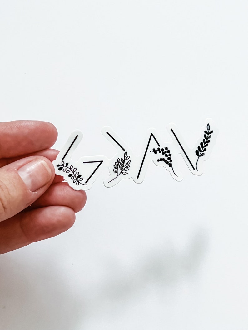 May include: A white sticker with the word "Grateful" written in black with a simple floral design.