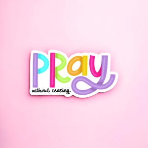 May include: A colorful sticker with the word "Pray" in a rainbow font. The sticker has a white border and the text "without ceasing." in black.