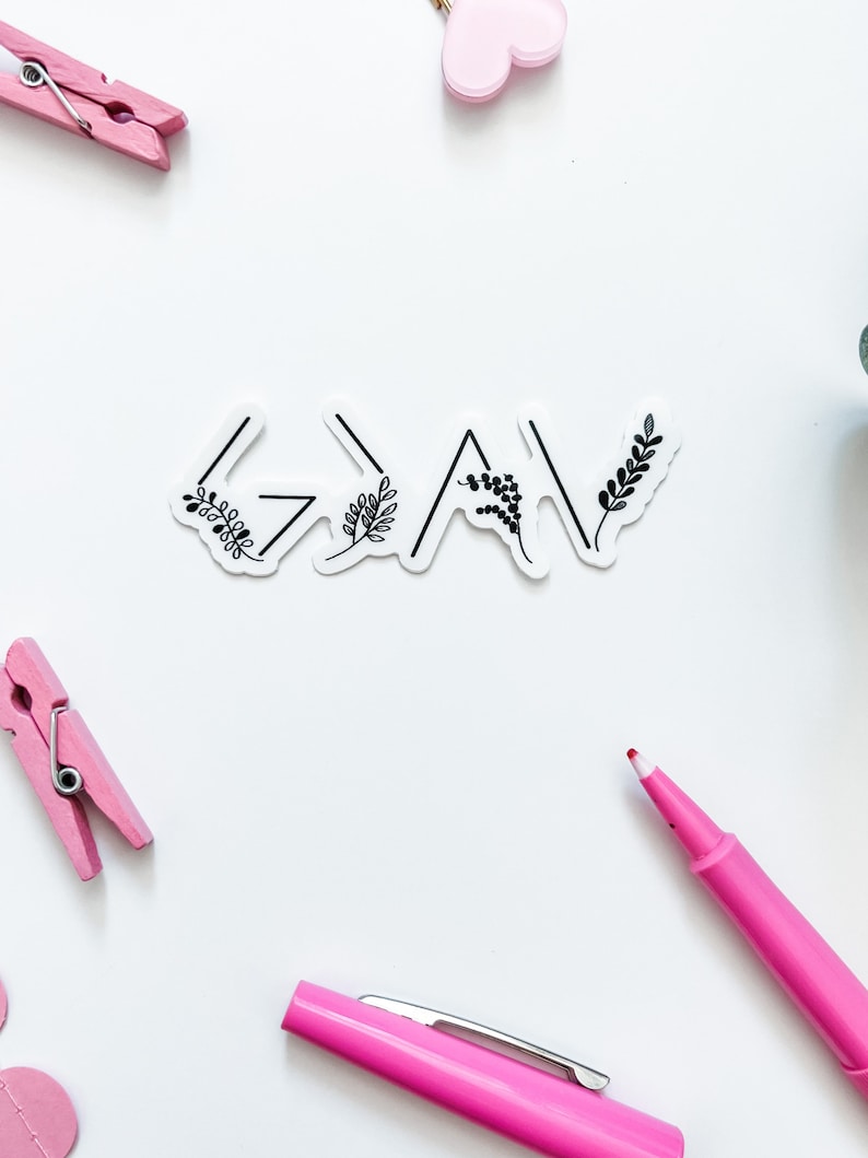 May include: A white sticker with the word "Grateful" written in black with a stylised arrow design and small floral accents.