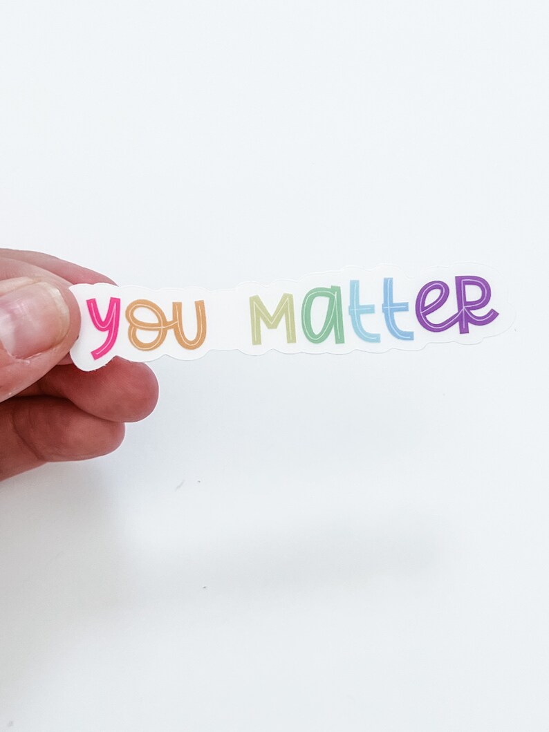 Op de afbeelding: Een sticker met de tekst "you matter" in regenboogkleuren. De sticker is op een witte achtergrond.