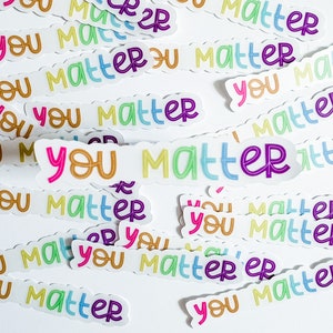 Op de afbeelding: Een verzameling kleurrijke stickers met de tekst "You Matter" erop. De stickers zijn willekeurig gerangschikt op een witte achtergrond.