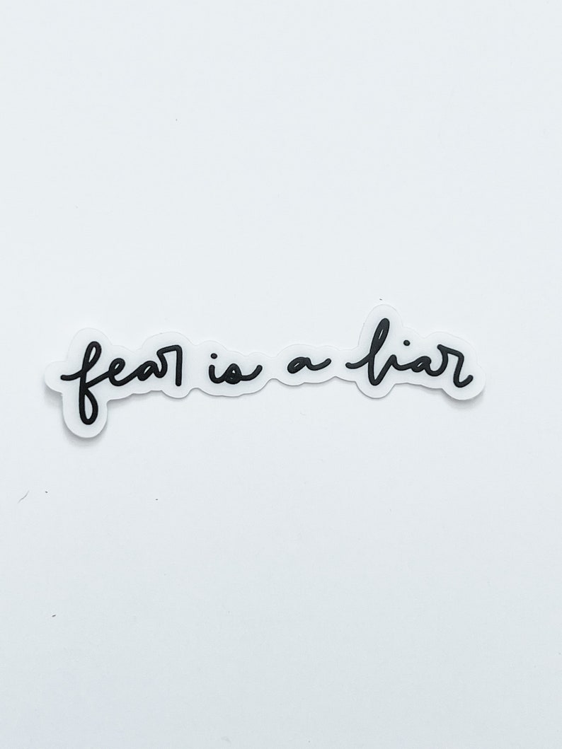 May include: Black and white handwritten text on a white background that reads "fear is a liar".