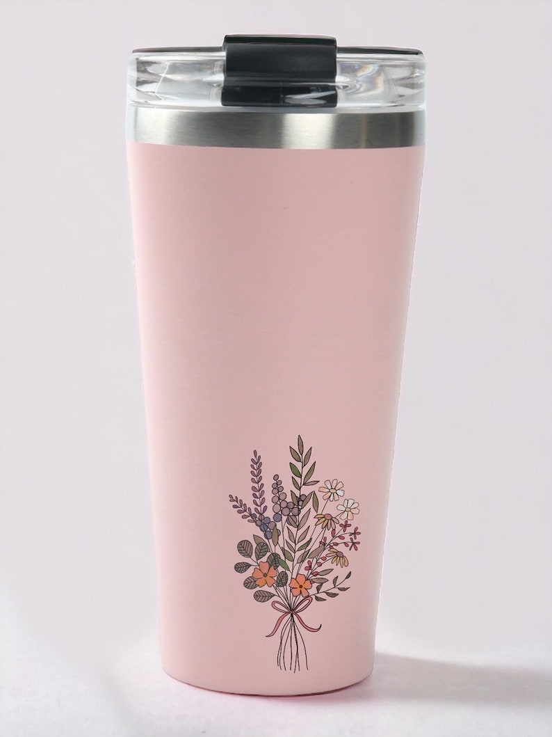 May include: A pink stainless steel travel mug with a black lid and a floral design. The design features a bouquet of flowers with orange, yellow, and purple accents.