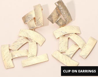 Auffällige, strukturierte, abstrakte geometrische Statement-Clip-Ohrringe in Gold.
