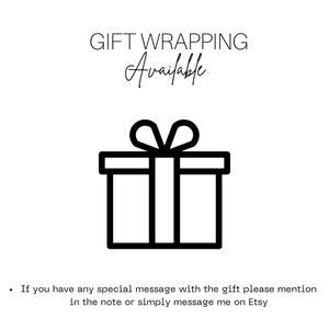 May include: A black and white graphic with the text "GIFT WRAPPING Available" above a simple line drawing of a gift box with a bow. The image is on a white background.