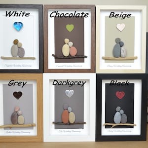 May include: Six framed pebble art pieces depicting a couple sitting on a branch with a heart above them. The frames are in various colors: white, chocolate, beige, grey, dark grey, and black. The text below each piece indicates the wedding anniversary represented. The text "These items are only for illustration, so you can pick your desired background colour." is visible in the bottom right corner.
