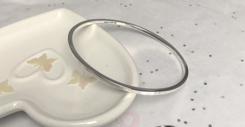 May include: A silver bangle bracelet with a smooth, polished finish.