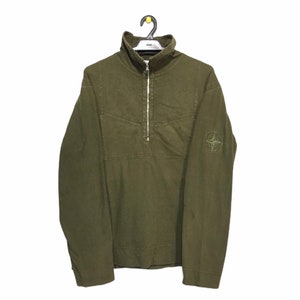 May include: A green long-sleeve zip-up sweatshirt with a compass logo on the left sleeve.