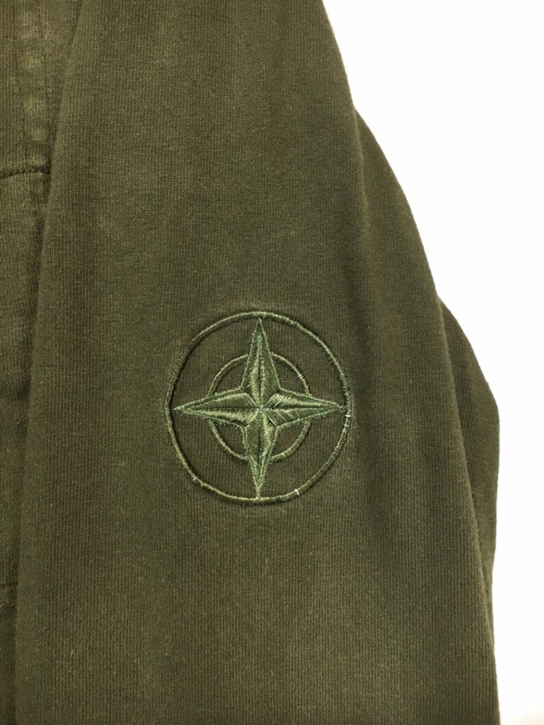 May include: A green hooded sweatshirt with a compass logo embroidered on the left sleeve.