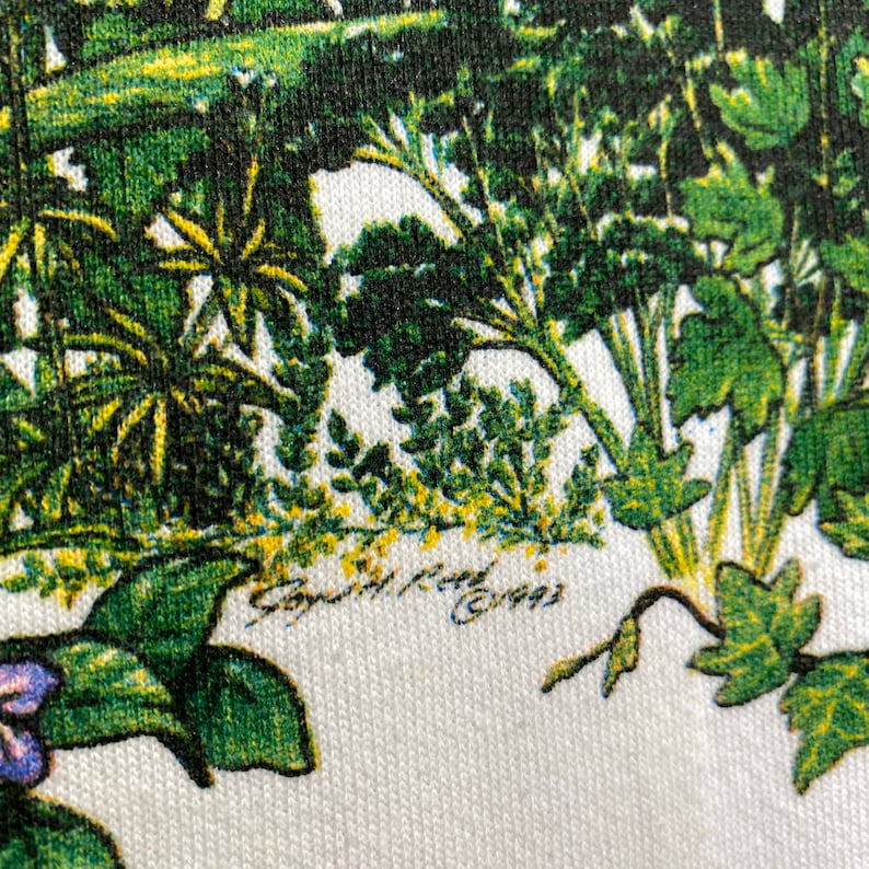 Op de afbeelding: Een witte stof met een groene en gele bloemenprint. De stof heeft een handtekening met de tekst "Smith & Evans 1993".