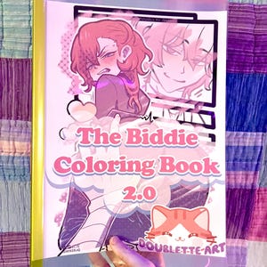 Peut inclure: Un livre de coloriage intitulé "The Biddie Coloring Book 2.0" avec du texte rose et blanc et des illustrations de personnages de style anime. La couverture présente une illustration de chat et le nom de l'artiste, "Doublette-Art."