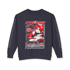 May include: A navy blue long-sleeve sweatshirt with a graphic print of a red car and a cartoon character. The text "R-TON MOBILE" is printed on the sweatshirt. The car is a 2024 Mazda MX-5 Miata Roadster.
