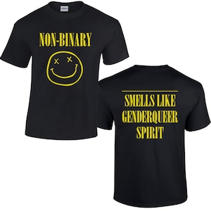 Op de afbeelding: Zwart T-shirt met een gele smiley en de tekst "NON-BINAIR" op de voorkant. De achterkant van het shirt heeft de tekst "RUIKT NAAR GENDERQUEER GEEST" in geel.