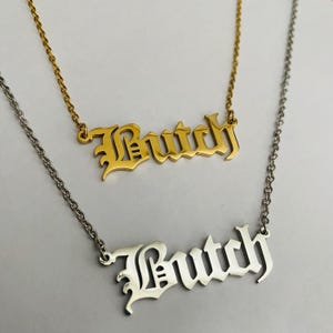 May include: Two gold and silver necklaces with the name "Butch" spelled out in old English lettering.