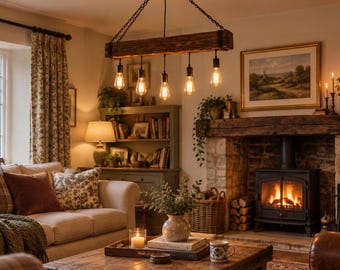May include: A rustic rectangular wooden beam chandelier suspended by black chains, featuring five downward-facing Edison-style light bulbs that emit a warm glow, centered above a living room space with a fireplace and wooden coffee table.