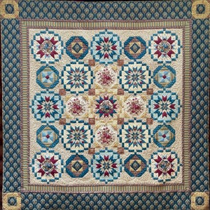 May include: A large, quilted blanket with a complex geometric pattern. The quilt features a central design of floral and starburst motifs in shades of red, blue, and gold, set against a cream background. The border is a repeating diamond pattern in teal and gold.