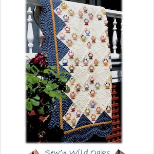 May include: A quilted blanket with a repeating basket pattern in various colors. The quilt features a cream-colored background with blue and gold borders. The text "FOR THE LOVE OF BASKETS" and "Sew'n Wild Oaks" are visible.