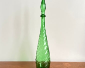 Peut inclure: Une carafe en verre vert translucide dotée d'un corps en forme de goutte d'eau avec un motif nervuré en spirale distinct et un bouchon en verre pointu et allongé assorti qui s'insère dans le goulot étroit du récipient.