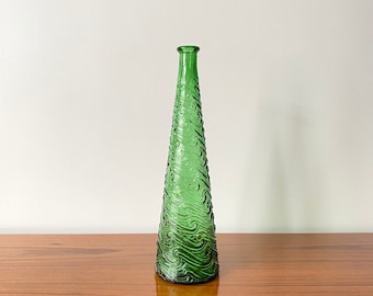 May include: A tall, conical green glass bottle featuring a textured surface with raised, swirling wave-like patterns. The bottle has a narrow neck and a small, circular opening at the top, tapering gradually from a wide base to the slender neck.