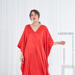 May include: A long, flowing, red V-neck kaftan made of 100% polyester satin. The kaftan has wide sleeves and a loose fit. The image includes the text "COZYCONY" and "V-NECK LONG KAFTAN : 100% POLYESTER SATIN".