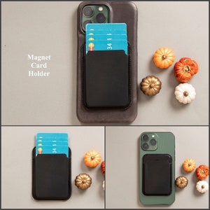 May include: A black leather phone case with a magnetic card holder attached to the back. The case is shown with a few credit cards in the holder. The case is shown on a white background with some small orange and white pumpkins.