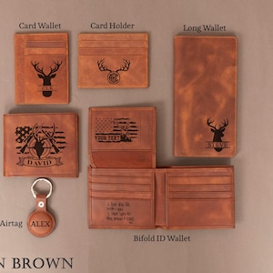 May include: A collection of tan brown leather wallets and accessories. Includes a card wallet, card holder, long wallet, bifold wallet, bifold ID wallet, and an airtag. Each item features a deer head design or personalized text.
