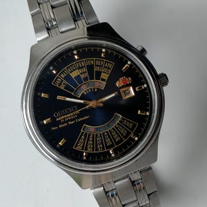 Orient College Automatic. Evig kalender. Modell EA 46D701-91 CA. Multiurtavla. Vintage original japansk mekanisk stor snygg klocka. 1990-talet