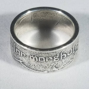 K&ouml;nnte beinhalten: Silberring aus einer wiederverwendeten M&uuml;nze. Der Ring tr&auml;gt eine Inschrift in einer Fremdsprache.