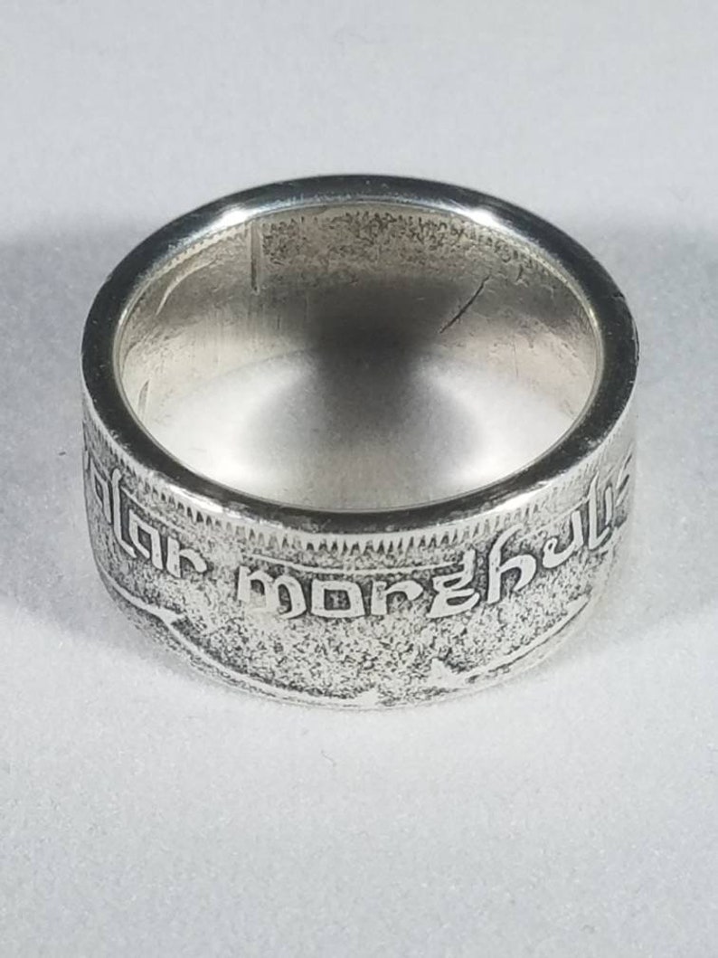 K&ouml;nnte beinhalten: Silberring aus einer wiederverwendeten M&uuml;nze. Der Ring tr&auml;gt eine Inschrift in einer Fremdsprache.