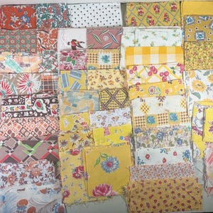 May include: A collection of vintage fabric squares in various patterns and colors. The fabrics include floral, polka dot, and geometric designs in shades of red, yellow, and white. Ideal for quilting or crafting projects.