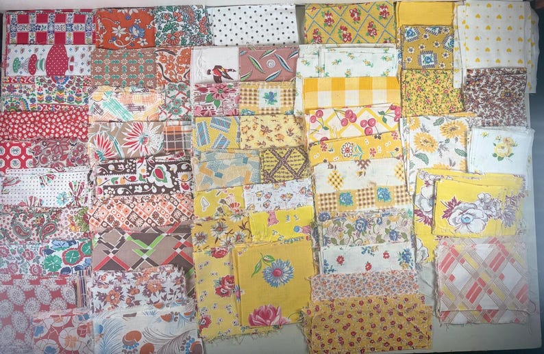 May include: A collection of vintage fabric squares in various patterns and colors. The fabrics include floral, polka dot, and geometric designs in shades of red, yellow, and white. Ideal for quilting or crafting projects.