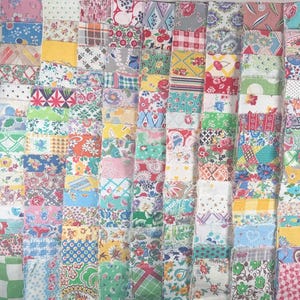 May include: A collection of colorful fabric squares arranged in a grid pattern. The squares feature a variety of floral, geometric, and patterned designs in shades of pink, blue, green, yellow, and red. The fabrics appear to be vintage or retro in style.