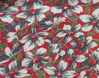 May include: Red fabric with a white and gray floral pattern. The flowers are stylized and have a vintage look.