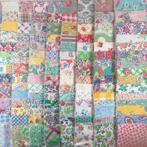 May include: A collection of fabric squares in various colors and patterns. The squares feature floral, geometric, and abstract designs in shades of red, blue, green, yellow, and pink. The arrangement creates a patchwork effect, ideal for quilting or crafting projects.