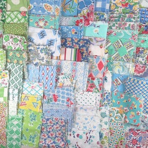 May include: A collection of vintage fabric pieces in various shades of green, blue, and white. The fabrics feature floral, geometric, and polka dot patterns. The pieces are neatly stacked, showcasing a variety of textures and designs, perfect for quilting or crafting projects.