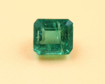 Puede incluir: Una gema de esmeralda verde vibrante tallada en forma de esmeralda.