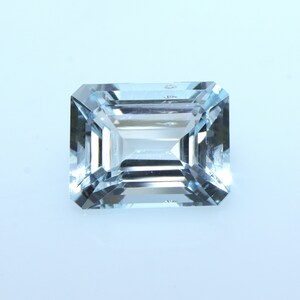 May include: A light blue aquamarine gemstone with an emerald cut.