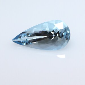 May include: A light blue pear-shaped aquamarine gemstone with a faceted cut.