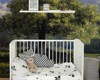 Op de afbeelding: Een wit babybedje met een zwart-wit gestreept beddengoed. Het babybedje staat voor een muurschildering met een grote groene boom met een blauwe lucht en witte wolken. Het babybedje heeft een knuffeldier en een kussen erop. Er is een klein plankje boven het babybedje met een ingelijst alfabetkaart en een klein speelgoedhuis.