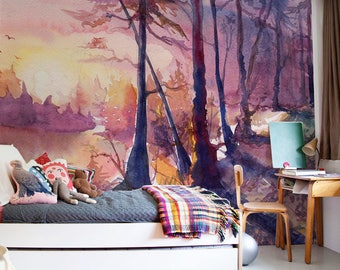 Op de afbeelding: Een kinderkamer met een aquarelmuurschildering van een boslandschap op de muur. Het bed is opgemaakt met een grijs dekbed en een geruit deken. Er liggen knuffels op het bed en een klein tafeltje met een tissuebox. In de hoek van de kamer staat een bureau met een stoel en een lamp.
