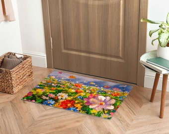 May include: A colourful doormat featuring a painting of a field of flowers in shades of pink, purple, yellow, red, and blue. The flowers are painted in a realistic style and the background is a soft blue.