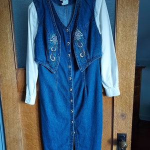 Emboidered denim dress by d.Frank. Mock jumper with set in white cuffed sleeves and anchored vest on the front. Slightly fitted.