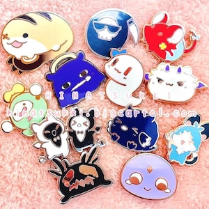 Puede incluir: Una colección de pines de esmalte con varios diseños de personajes de dibujos animados. Los pines presentan una gama de colores, incluyendo amarillo, azul, rojo, blanco y negro. Algunos pines tienen el texto "HINATSUKKI.bigcartel.com".