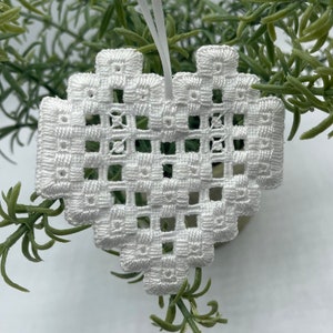 May include: White crocheted heart ornament with a delicate openwork design.