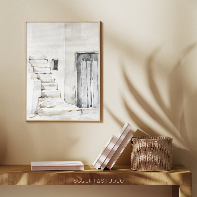 May include: A watercolor painting of a white building with a doorway and a set of stairs leading up to it. The painting is framed and hanging on a wall.