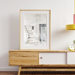 May include: A framed watercolor painting of a white building with a doorway and a set of stairs leading up to it. The painting is in a light wood frame and is hanging on a white wall.